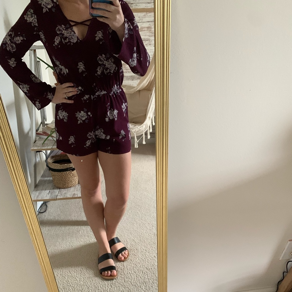 Purple long sleeve romper with floral details.